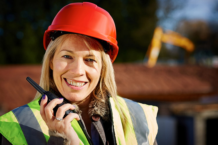 Female construction worker talking on walkie talkie